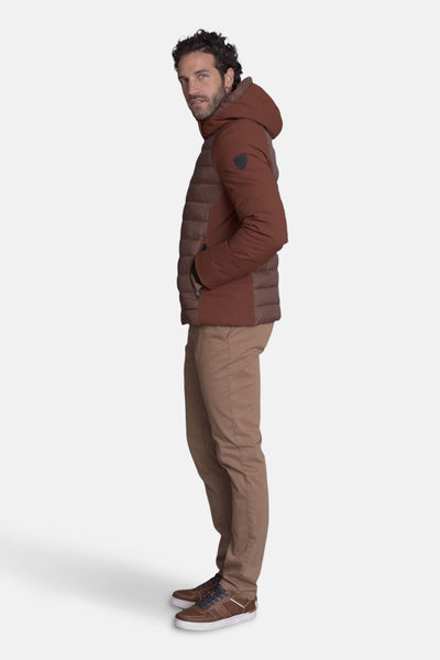 Bodywarmer beige van DELAHAYE, avec capuche et fermeture éclair, porté avec un pantalon chino marron et des baskets en cuir.