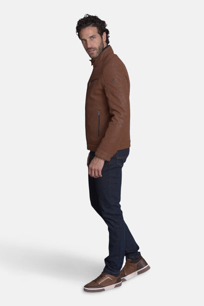 Veste courte en cuir brun de DELAHAYE, portée avec un jean et des chaussures de sport.