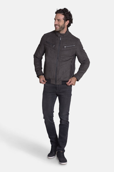 Veste courte brune de DELAHAYE, avec fermeture éclair et poches zippées, portée avec un jean noir et des baskets.
