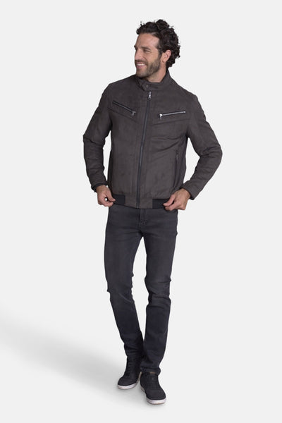 Veste courte brune de DELAHAYE, avec fermeture éclair et poches zippées, portée avec un jean noir et des baskets.

