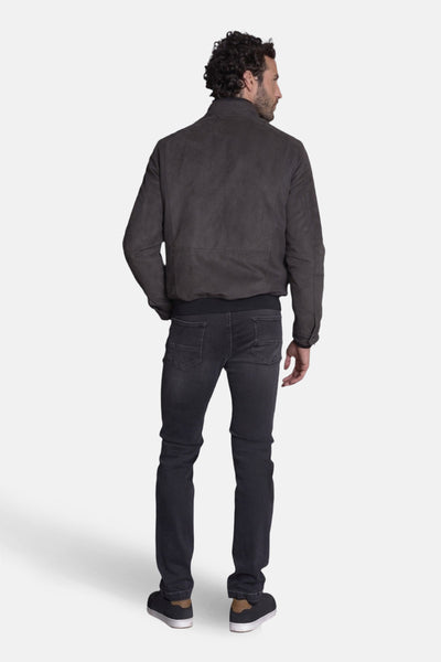 Veste courte brune par DELAHAYE, avec fermeture éclair, portée avec un jean noir et des baskets.