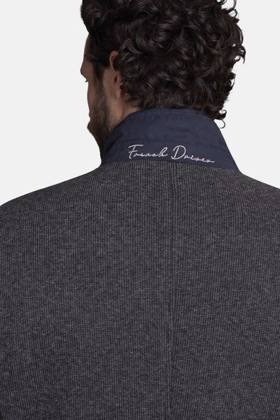 Veste longue grise de DELAHAYE, avec un col bleu marine et l'inscription "French Driver" brodée.