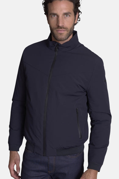 Kort blauw jasje van DELAHAYE, met zwarte ritssluiting en details van zakken met rits, gedragen over een spijkerbroek.
