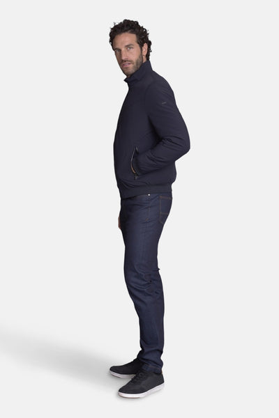 Kort marineblauw jasje van DELAHAYE, gedragen met een donkerblauwe jeans en zwarte sneakers, zijwaarts gezien.