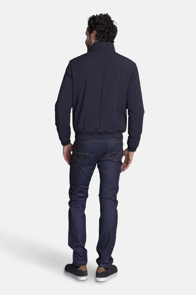 Veste courte bleue de DELAHAYE, vue de dos, portée avec un jean foncé et des baskets noires.