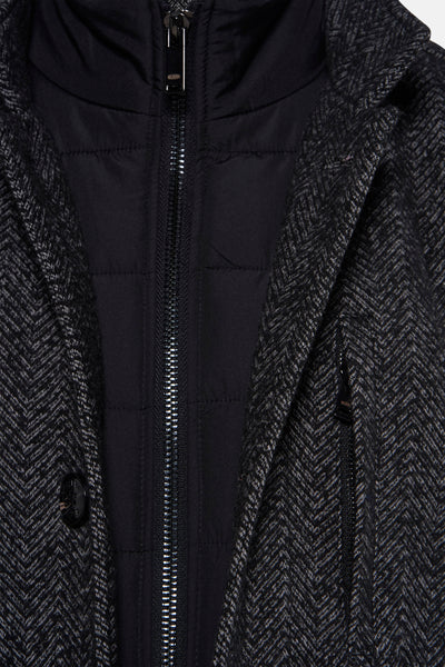 Veste longue grise à chevrons par Delahaye, avec capuche, rembourrage matelassé et fermeture éclair argentée.