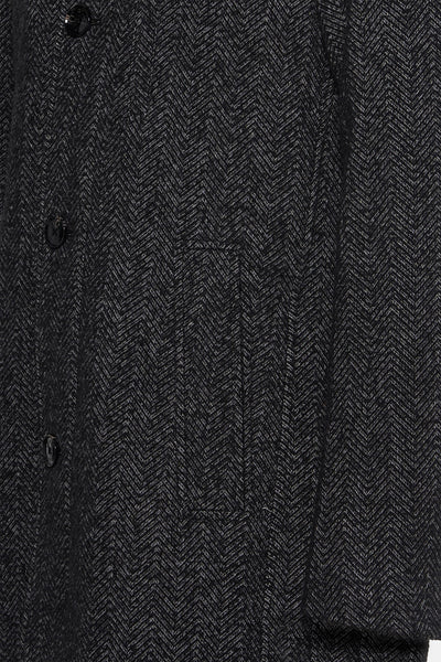 Veste longue grise à chevrons par DELAHAYE, avec une poche et des boutons noirs.
