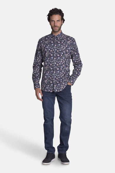 Chemise bleue à motifs floraux par DELAHAYE, portée avec un jean et des chaussures foncées.
