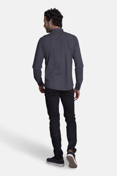 Blauwe DELAHAYE blouse met lange mouwen en een discreet patroon, gedragen met een zwarte broek en casual schoenen.