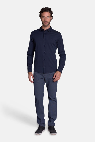 Navy blue long-sleeve button-down chemise with classic collar, worn by model in full-length front view with dark trousers and black sneakers.