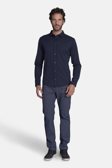 Chemise bleu à manches longues de DELAHAYE, boutonnée et portée avec un pantalon assorti.