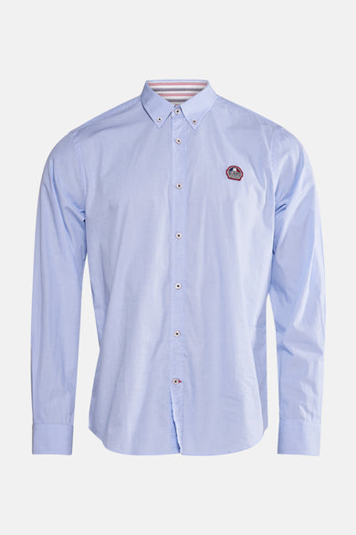 Chemise bleue à manches longues de DELAHAYE, avec un écusson sur la poitrine et des boutons blancs.