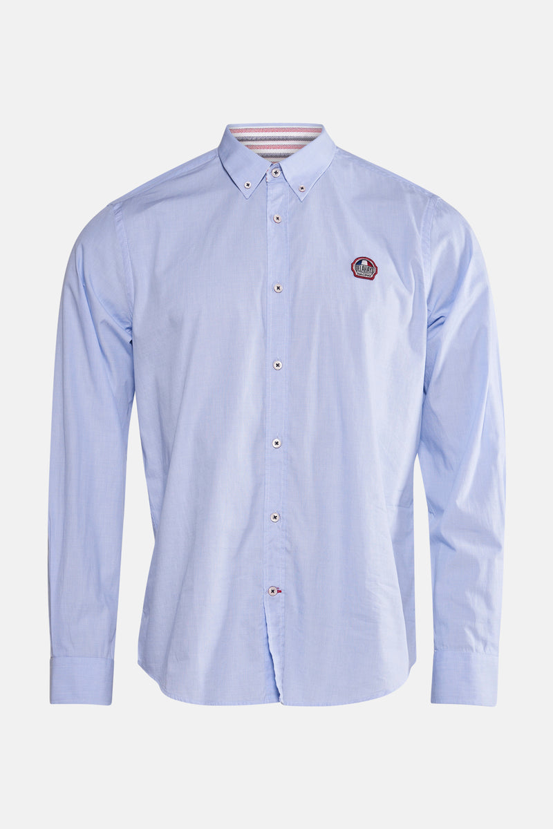 Chemise bleue à manches longues de DELAHAYE, avec un écusson sur la poitrine et des boutons blancs.