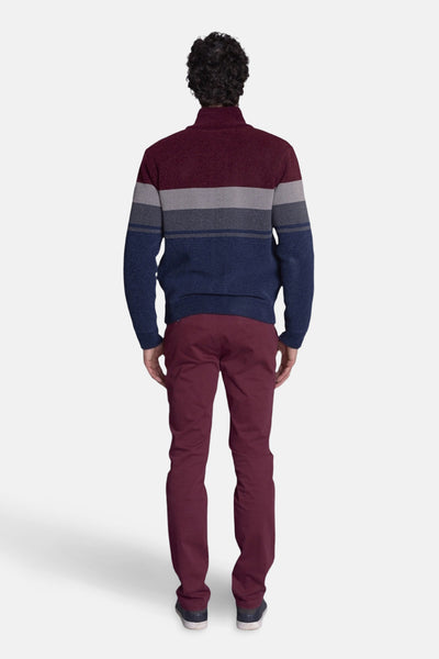 Multikleurend gilet van DELAHAYE met horizontale strepen en een bordeauxrode broek gedragen met schoenen.