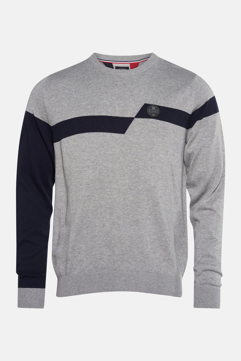 Pull gris de DELAHAYE, avec rayure marine asymétrique et logo rond sur la poitrine.
