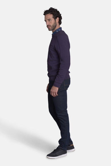 Pull col rond mauve de DELAHAYE porté avec un jean bleu marine et des baskets noires, vue de profil.
