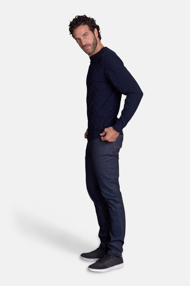 Navy long-sleeve polo with subtle textured pattern, side view on model wearing dark jeans and sneakers