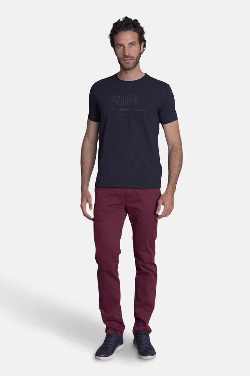 T-shirt bleu marine de Delahaye, porté avec un pantalon bordeaux et des chaussures bateau bleu marine.