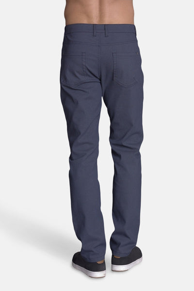 Pantalon bleu de DELAHAYE, avec poches arrière, porté avec des chaussures de sport noires, vue de dos.
