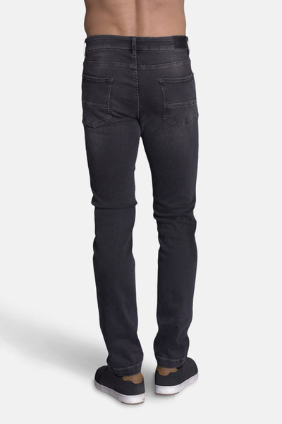 Jean slim en denim gris foncé de DELAHAYE, vue de dos, porté avec des chaussures décontractées.
