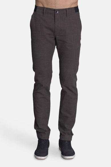 Pantalon brun par DELAHAYE, avec une texture subtile et des chaussures de sport noires.