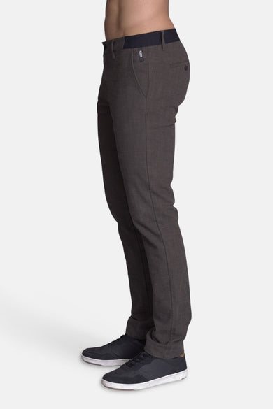 Pantalon brun de DELAHAYE, coupe ajustée, porté avec des baskets noires à semelles blanches.