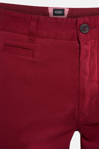 Chino rouge par Delahaye, avec une poche passepoilée et une texture en sergé.