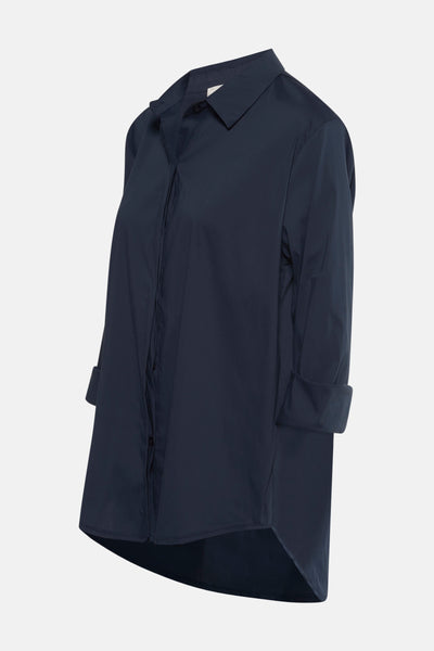Chemise à manches longues bleue de Terra di Siena, avec manches retroussées et ourlet asymétrique visible.