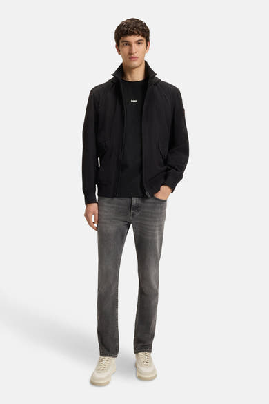 T-shirt à manches courtes noir de BOSS ORANGE, porté avec une veste et un jean gris délavé