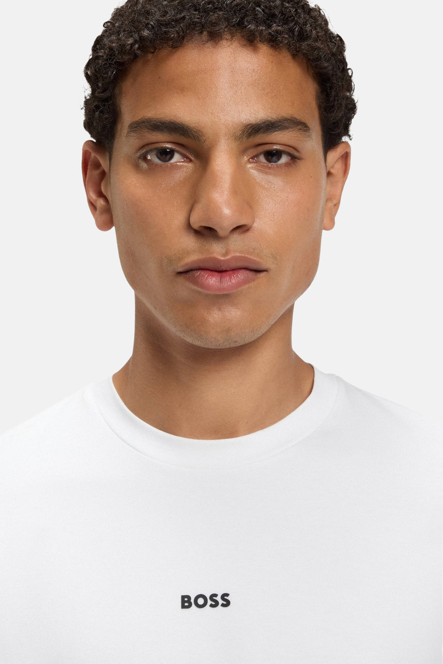 T-shirt blanc à manches courtes de BOSS ORANGE, porté par un homme à la peau bronzée.