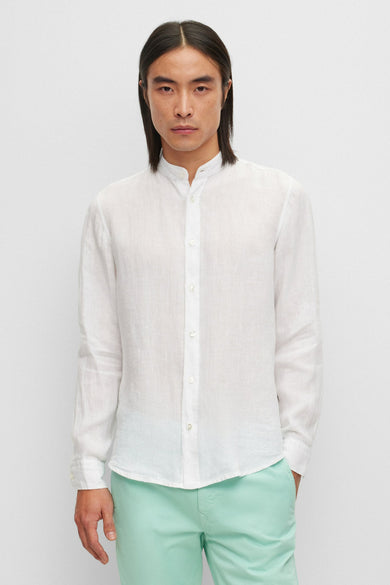 Chemise blanche à manches longues de BOSS ORANGE, portée avec un pantalon vert d'eau.