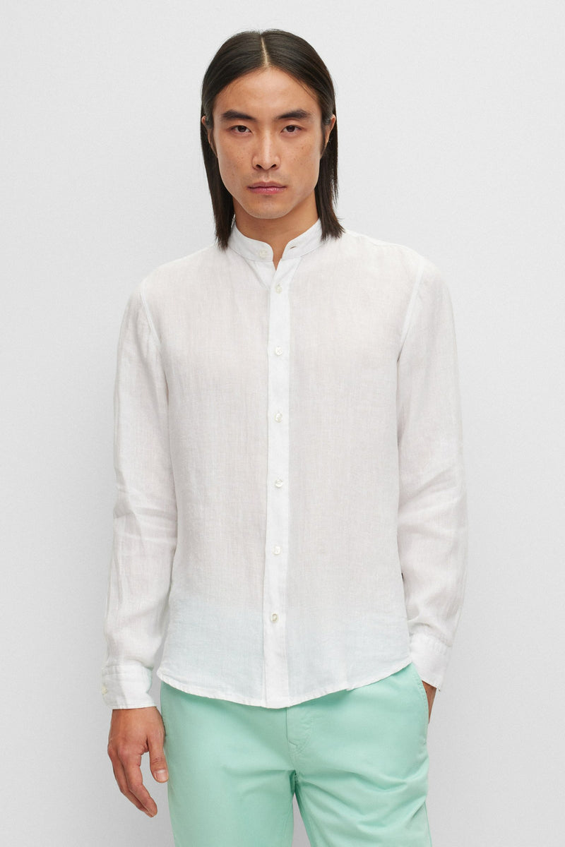 Chemise blanche à manches longues de BOSS ORANGE, portée avec un pantalon vert d'eau.