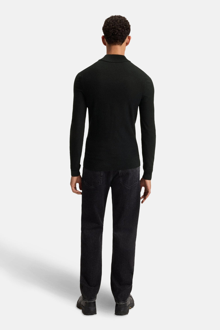 Blauwe coltrui van BOSS ORANGE, gedragen met een zwarte jeans en schoenen.