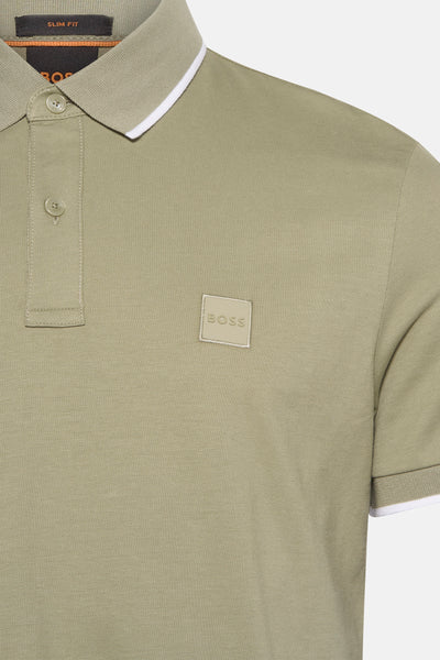 Polo vert à manches courtes de BOSS ORANGE, avec une bordure blanche au col et aux manches.