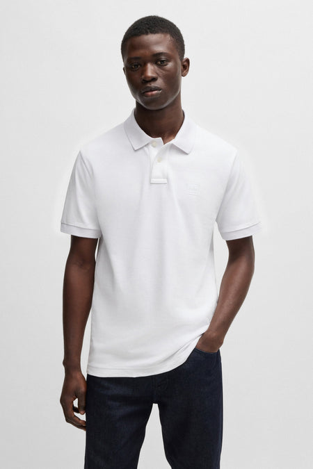 Witte korte mouw polo van BOSS, gedragen door een man met een geknoppte collar.