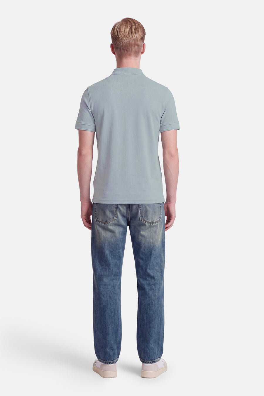 Polo gris à manches courtes de BOSS ORANGE, vue arrière, porté avec jeans délavés et baskets blanches