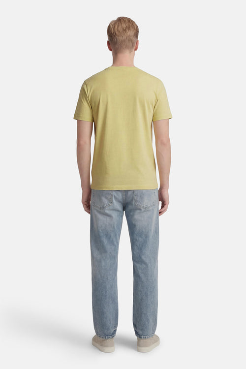 T-shirt vert de BOSS ORANGE, porté avec un jean bleu et des chaussures beiges, vue de dos.