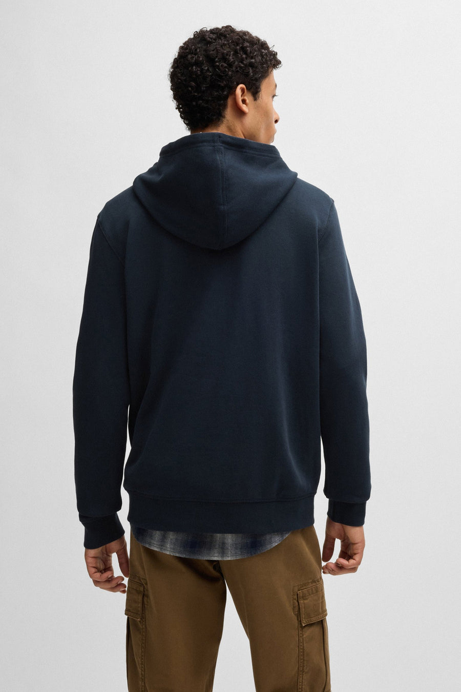 Blauwe BOSS ORANGE hoodie, met capuchon en gedragen over een geruit overhemd, van achteren gezien.