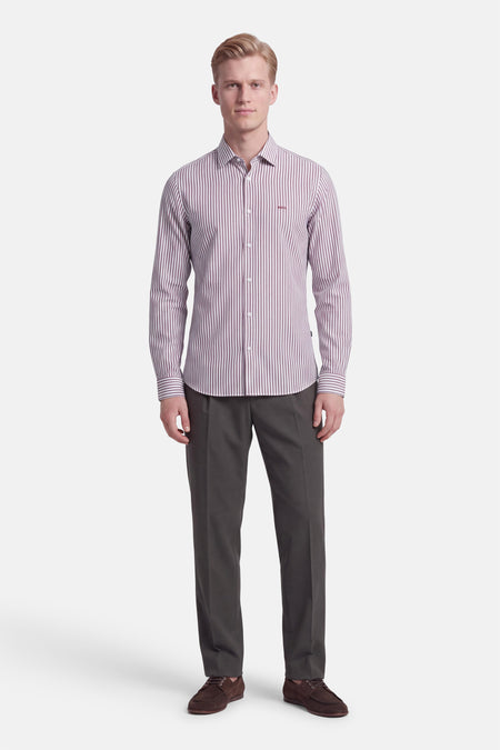 Chemise à manches longues rouge rayée par BOSS ORANGE, vue de face, boutonnée, avec logo discret sur poitrine, portée avec pantalon gris et chaussures marron