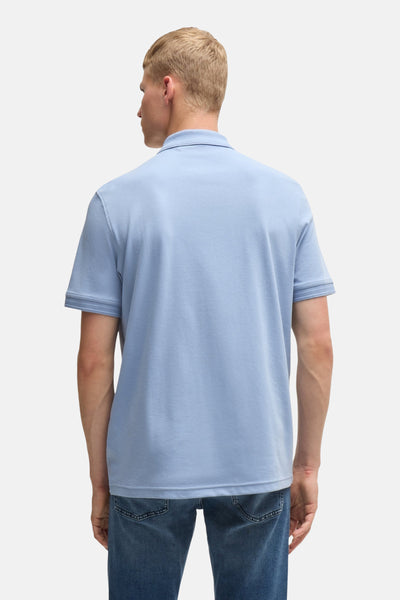 Polo bleu de BOSS ORANGE, avec des manches courtes et porté avec un jean en denim.