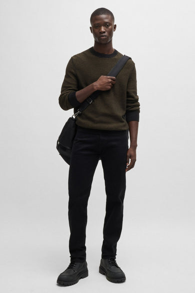 Pull à col roulé noir de BOSS ORANGE, avec un motif rayé horizontal, porté avec un pantalon et des chaussures noirs.
