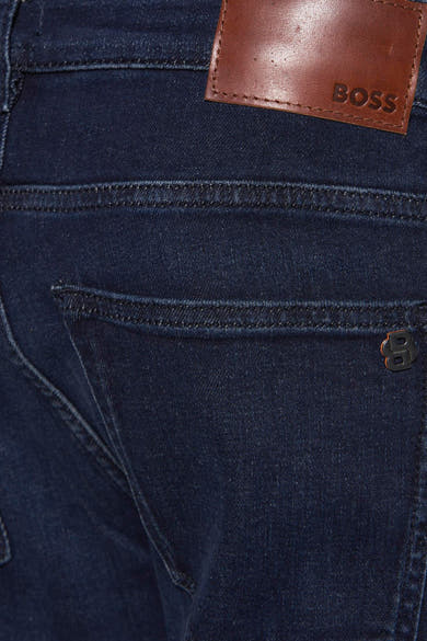 Jean slim en denim bleu foncé de BOSS ORANGE avec étiquette en cuir et logo métallique sur la poche.