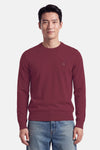 Pull col rond rouge de BOSS ORANGE, coupe ajustée, détail logo discret sur poitrine, porté avec jeans délavés, vue frontale.