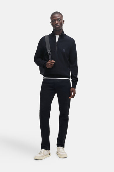 Blauwe coltrui van BOSS ORANGE, gedragen met een wit T-shirt en een zwarte broek.