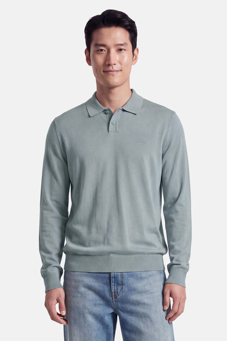 Pull gris à col polo de BOSS ORANGE, avec broderie discrète sur poitrine, manches longues et ourlet côtelé, porté avec jeans délavés.
