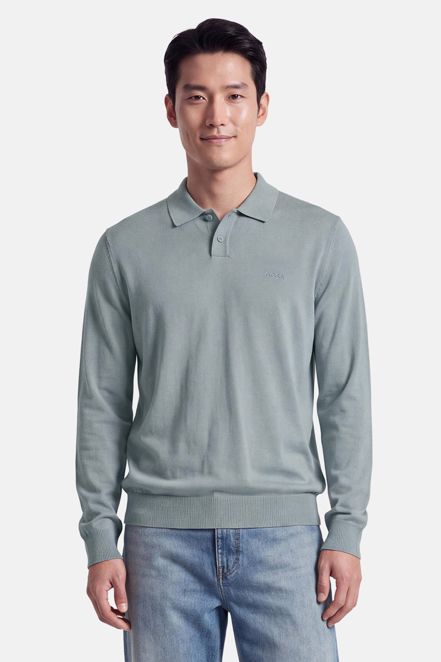 Pull gris à col polo de BOSS ORANGE, avec broderie discrète sur poitrine, manches longues et ourlet côtelé, porté avec jeans délavés.