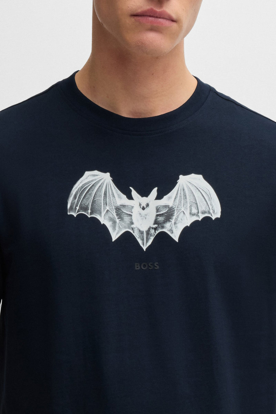 T-shirt bleu à manches courtes de BOSS ORANGE, avec un imprimé de chauve-souris blanc sur le devant.