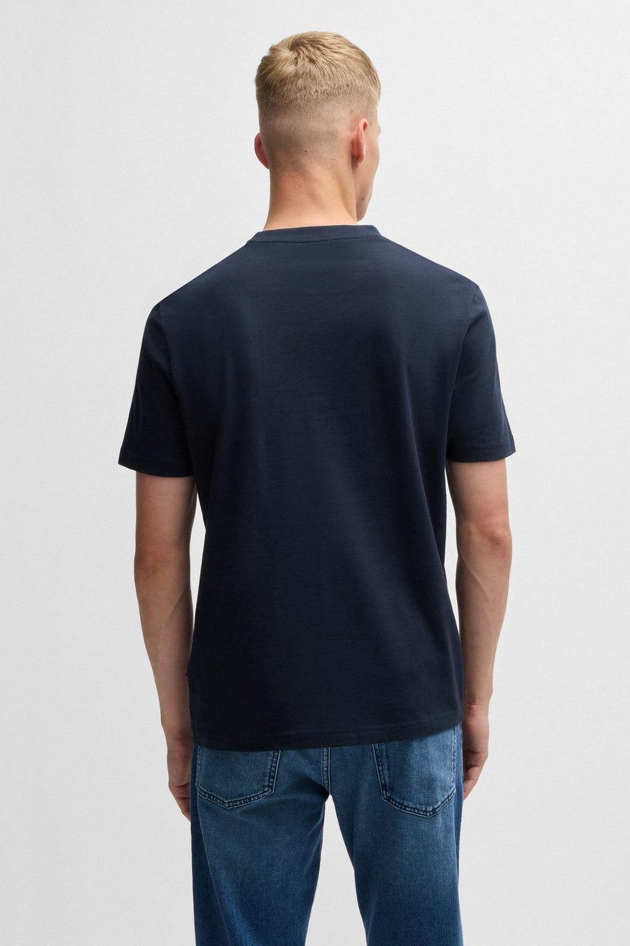 Marineblauw T-shirt met korte mouwen van BOSS ORANGE, van achteren gezien, gedragen met een spijkerbroek.