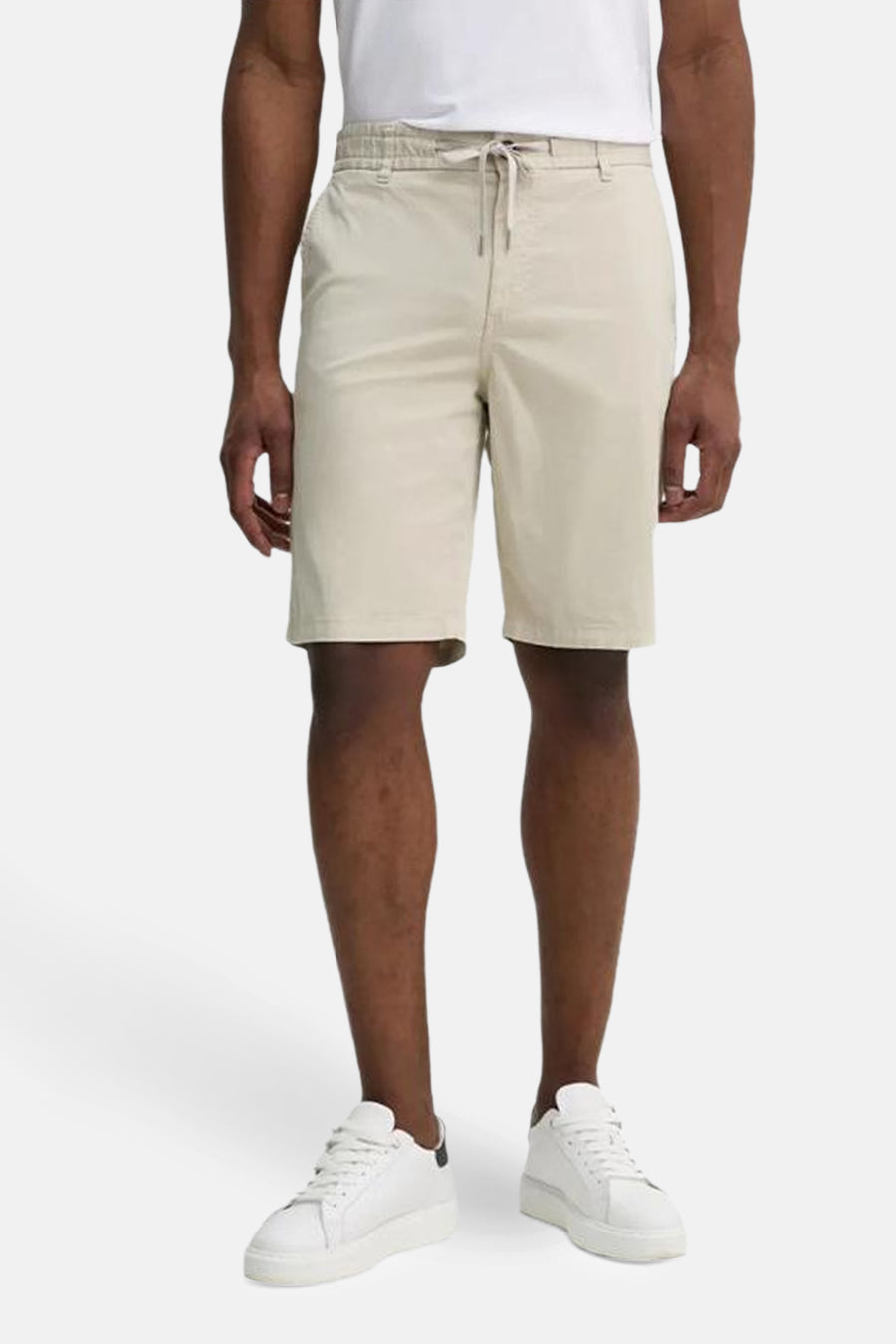 Short beige de BOSS ORANGE, porté avec un t-shirt blanc et des baskets blanches.