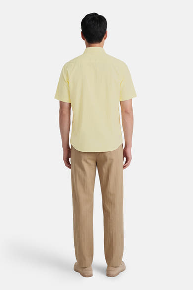 Chemise à manches courtes verte de BOSS ORANGE, avec manches courtes et coupe classique, portée avec un pantalon marron.